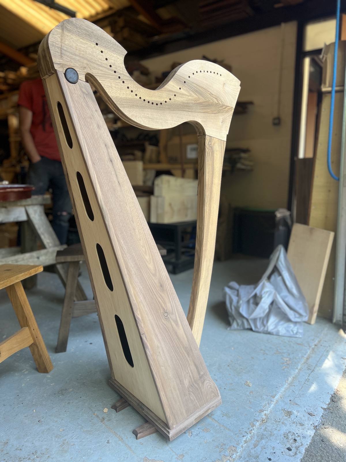 A Celtic lever harp in build, standing in the workshop