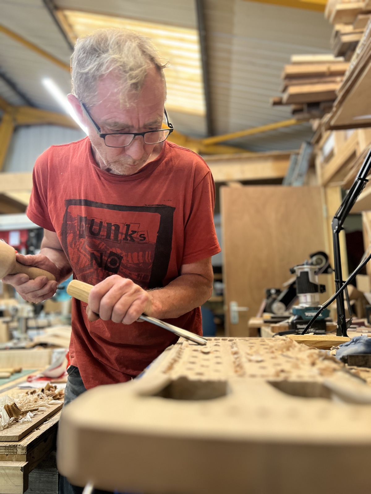 Richard Stephenson at the bench, carving a crwth body with a chisel