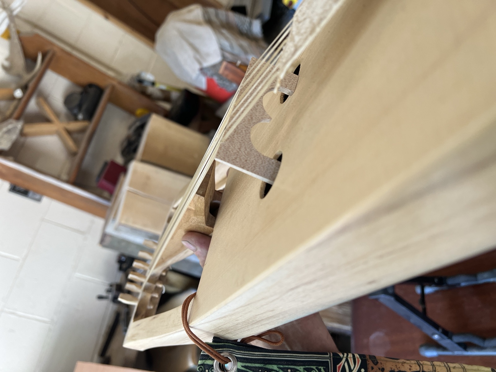 A carved bridge and soundholes sighted down a crwth's soundboard